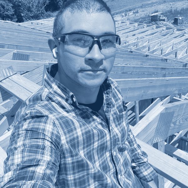 Charles on the roof trusses of a house under construction