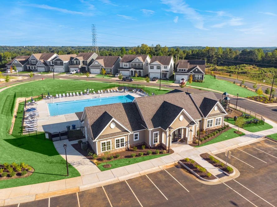 Aerial view of the Collins Ridge clubhouse and saltwater pool, with finished homes behind